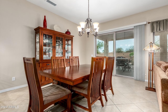 tiled dining room featuring a chandelier