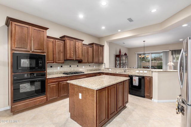 kitchen with black appliances, kitchen peninsula, pendant lighting, a kitchen island, and an inviting chandelier