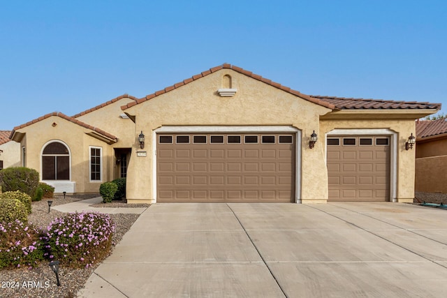 mediterranean / spanish-style house with a garage