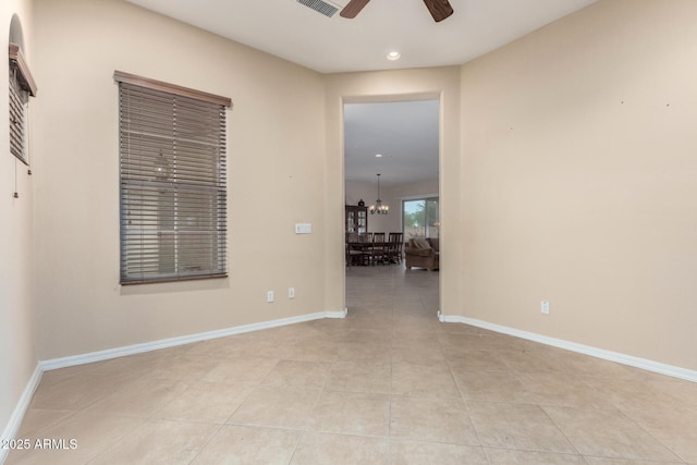 empty room featuring ceiling fan with notable chandelier and light tile patterned floors