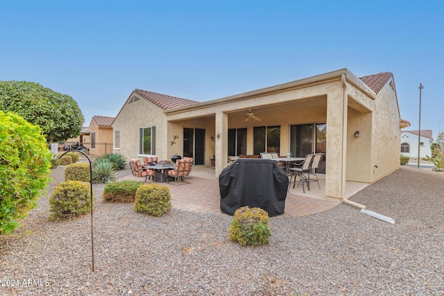 rear view of house with ceiling fan and a patio