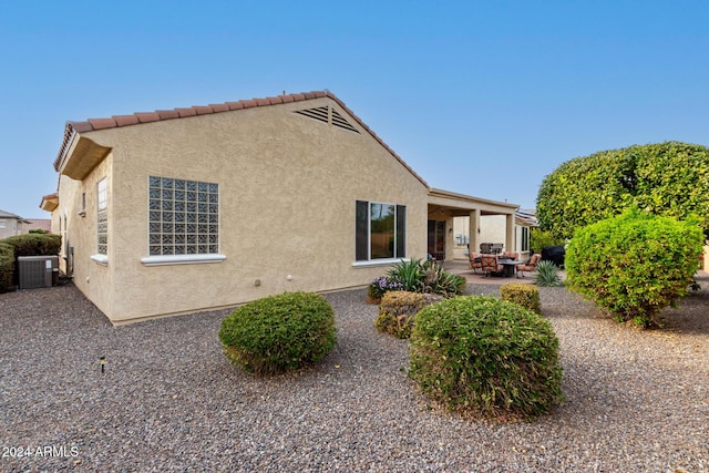 view of property exterior featuring central air condition unit and a patio