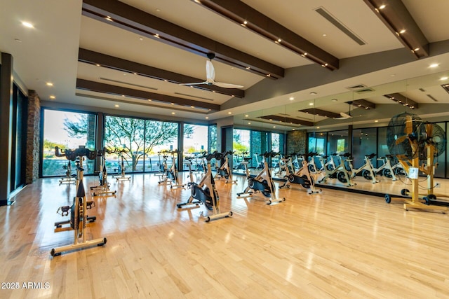 gym featuring vaulted ceiling, ceiling fan, light hardwood / wood-style floors, and expansive windows