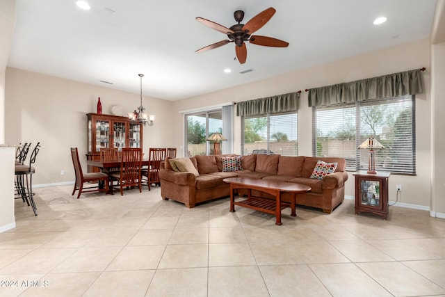 living room with light tile patterned flooring and ceiling fan with notable chandelier