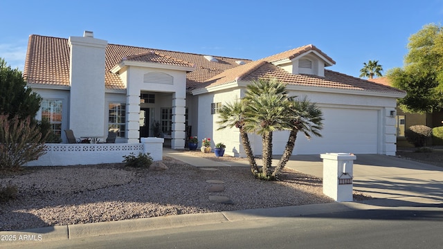 mediterranean / spanish home with a garage, a tile roof, driveway, and stucco siding