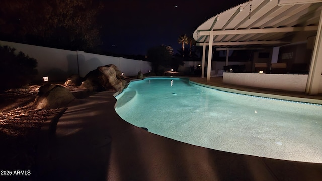 pool at twilight featuring a fenced in pool and fence