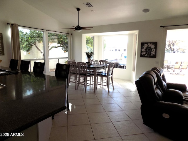 dining room featuring lofted ceiling, light tile patterned floors, visible vents, and a wealth of natural light