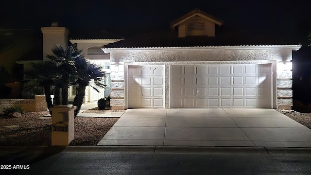 view of front facade with a garage, stone siding, and driveway