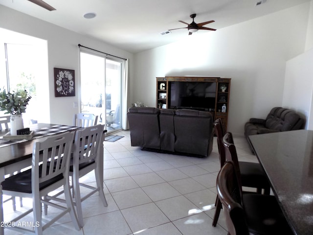 dining area featuring light tile patterned floors, visible vents, lofted ceiling, and a ceiling fan