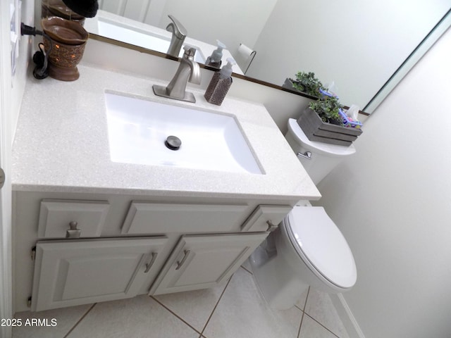 half bathroom featuring toilet, vanity, and tile patterned floors