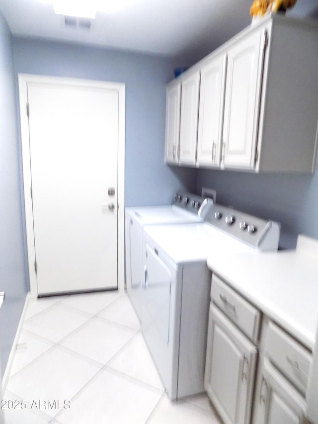 washroom featuring cabinet space, light tile patterned floors, visible vents, and independent washer and dryer