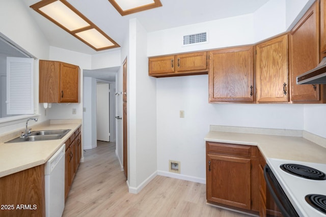 kitchen with dishwasher, range hood, sink, and light hardwood / wood-style flooring