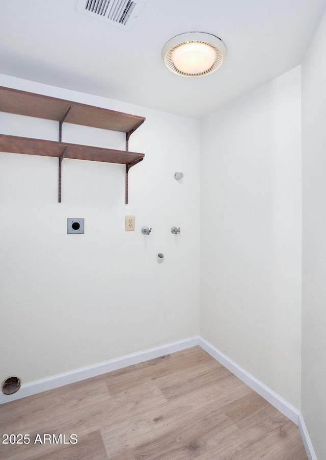 clothes washing area featuring washer hookup, hookup for an electric dryer, hookup for a gas dryer, and light hardwood / wood-style flooring