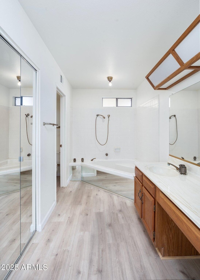 bathroom with vanity, hardwood / wood-style floors, and shower with separate bathtub