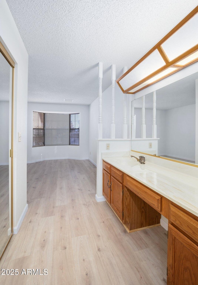 bathroom featuring wood-type flooring, vanity, and a textured ceiling