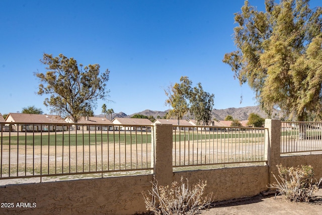 view of gate featuring a mountain view and a yard