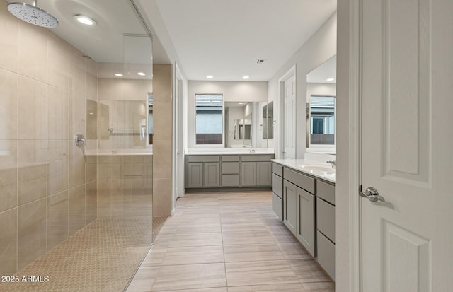 bathroom featuring vanity, tile patterned flooring, and tiled shower