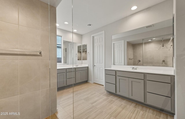 bathroom featuring vanity and tiled shower