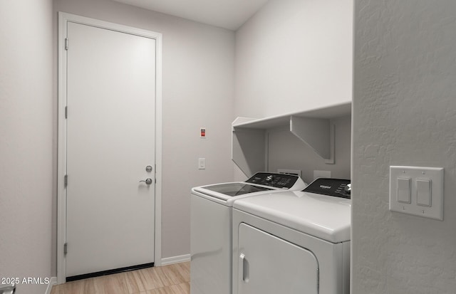 washroom with light hardwood / wood-style floors and washer and dryer