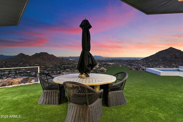 view of yard featuring an in ground hot tub, outdoor dining area, and a mountain view