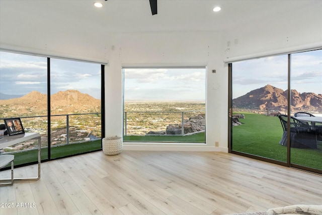 sunroom / solarium featuring a mountain view and a ceiling fan