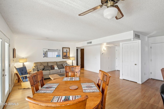 dining room featuring ceiling fan, a textured ceiling, and light wood-type flooring