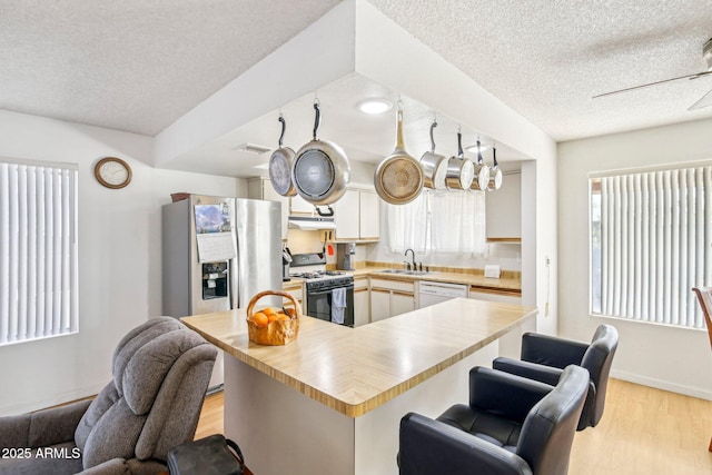 kitchen featuring sink, range with gas cooktop, dishwasher, light hardwood / wood-style floors, and white cabinets