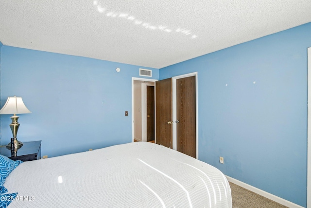 bedroom featuring carpet floors and a textured ceiling