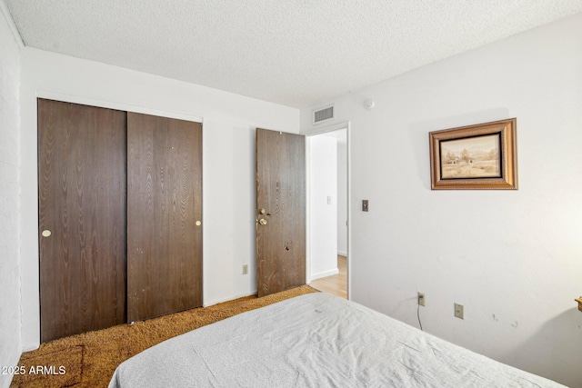 bedroom featuring a textured ceiling and a closet