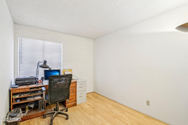 office with light hardwood / wood-style floors and a textured ceiling