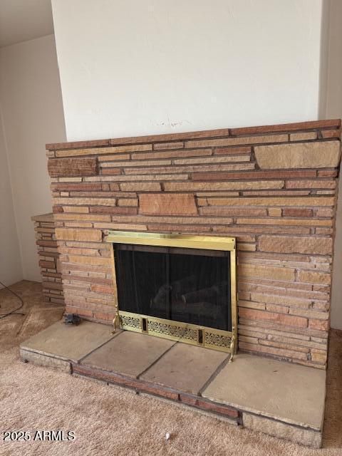 detailed view of carpet flooring and a fireplace