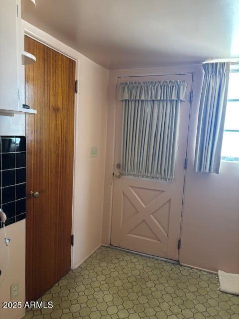 doorway to outside with a fireplace and light floors