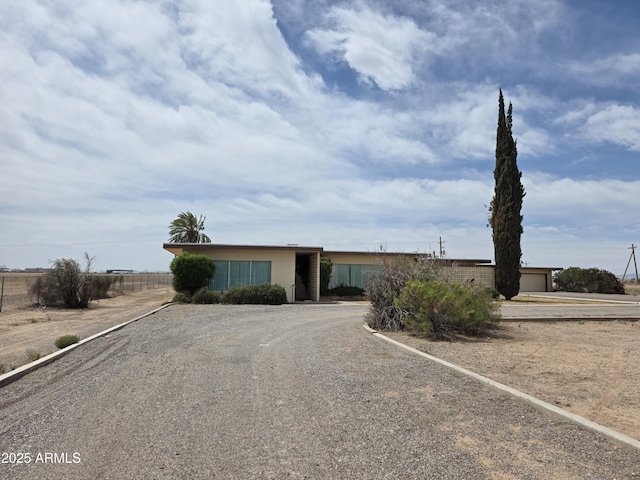 view of front facade with driveway, fence, and a garage