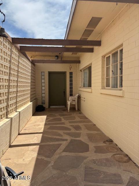 view of exterior entry with a patio