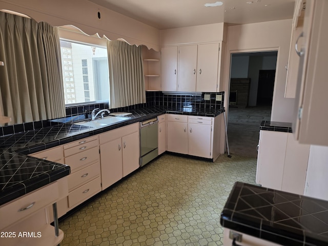 kitchen with dishwasher, white cabinetry, open shelves, and tile counters