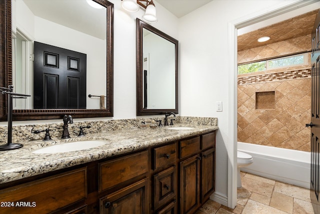 full bathroom with tiled shower / bath, vanity, and toilet