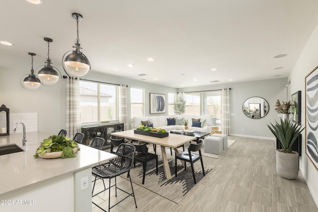 dining area with sink, light hardwood / wood-style floors, and a healthy amount of sunlight