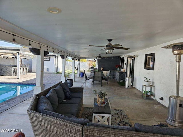 view of patio with ceiling fan, an outdoor living space, and exterior bar