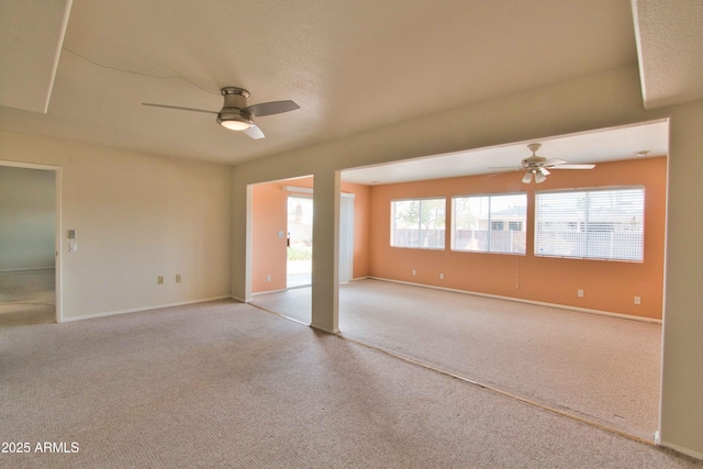 carpeted empty room with baseboards and a ceiling fan