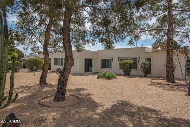 rear view of house featuring stucco siding