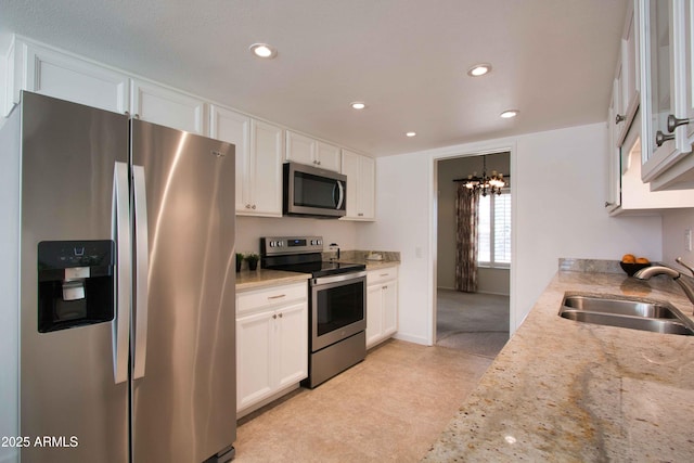 kitchen with a sink, white cabinets, recessed lighting, and stainless steel appliances