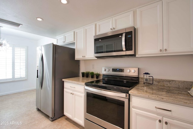 kitchen with visible vents, white cabinets, and stainless steel appliances