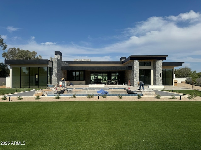 12232 N 65th Pl, Scottsdale, AZ 85254 - back of house with stone siding, a patio area, a covered pool, and a lawn