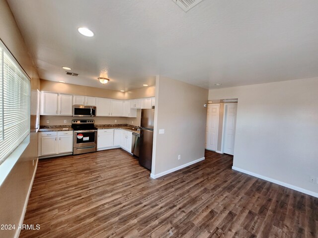 kitchen featuring dark hardwood / wood-style floors, stainless steel appliances, light stone countertops, and white cabinets