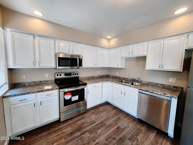 kitchen with sink, dark hardwood / wood-style floors, stainless steel appliances, and white cabinetry