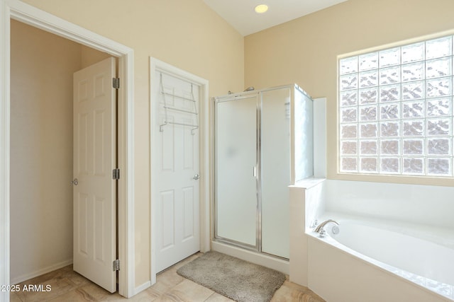 bathroom featuring a healthy amount of sunlight, shower with separate bathtub, and tile patterned flooring