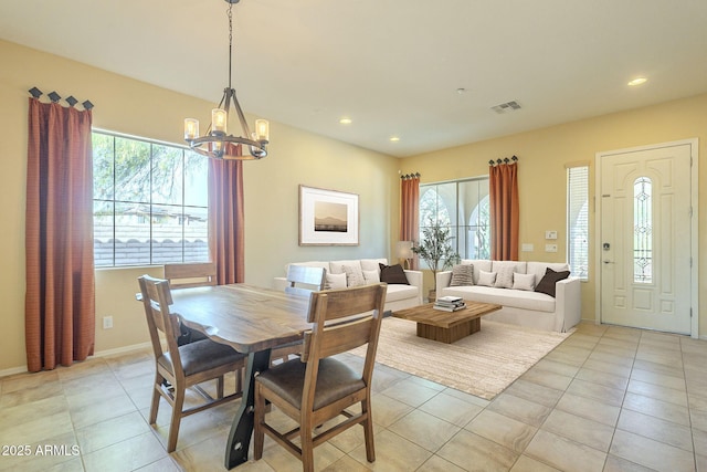 tiled dining area featuring a chandelier