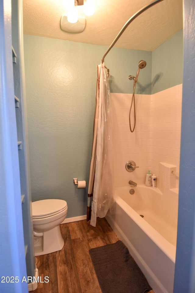 bathroom featuring toilet, hardwood / wood-style floors, and shower / bath combo with shower curtain