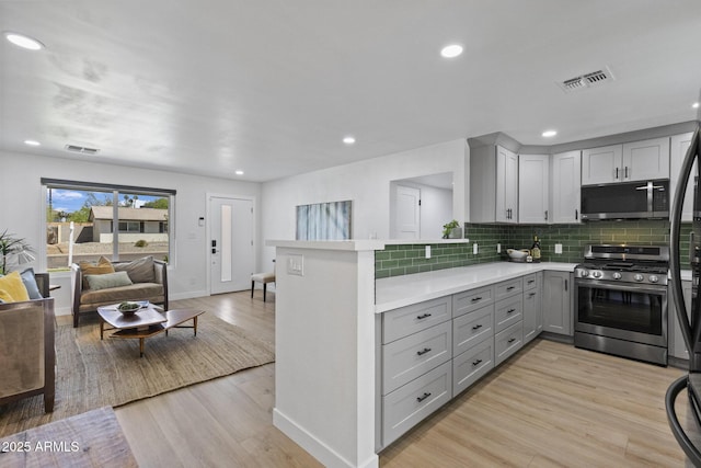 6723 E 1st Ave, Scottsdale, AZ 85251 - kitchen with appliances with stainless steel finishes, gray cabinetry, open floor plan, light countertops, and tasteful backsplash