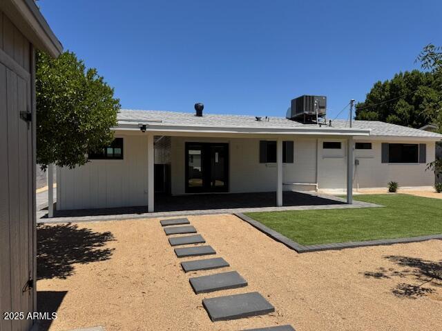 6723 E 1st Ave, Scottsdale, AZ 85251 - back of property with a patio area, central AC unit, and a lawn